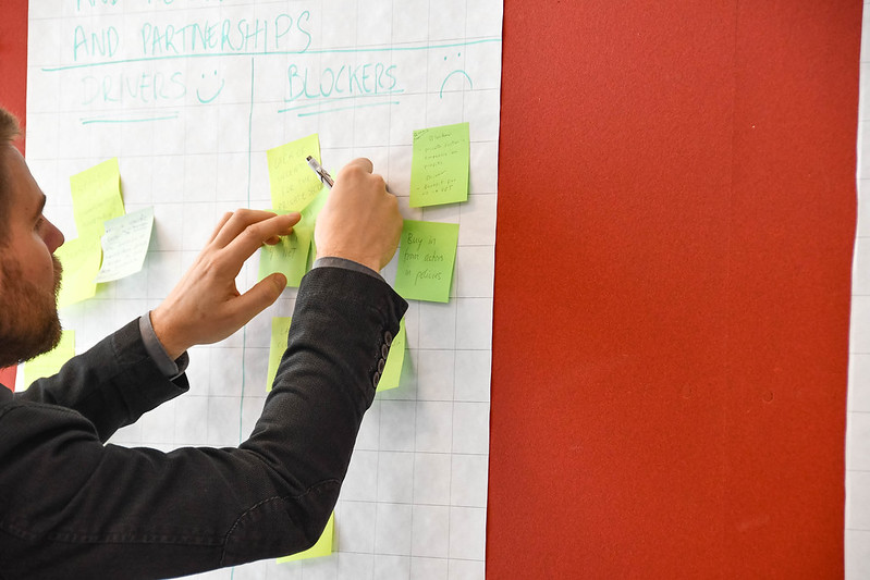 A man placing post-it notes on wall