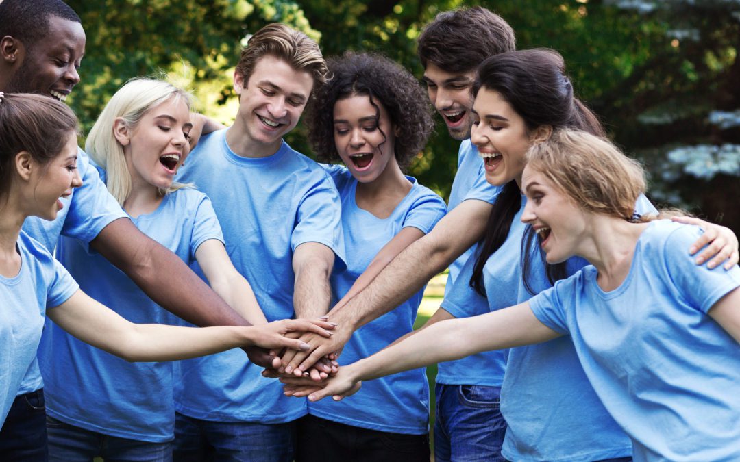 Young happy volunteers outdoor meeting at park